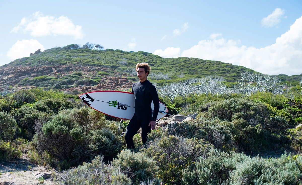 Surfer wearing an eco wetsuit made with neoprene-free, recycled materials