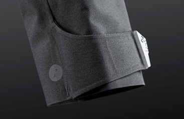 Close-up of the leg hem of dark grey technical shorts with a press stud and adjuster tab