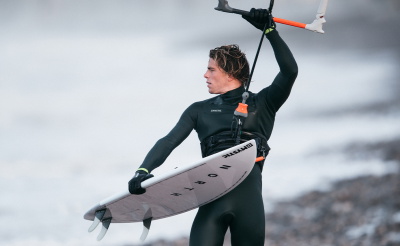 Riders van het Mystic-team in hun wetsuits uit de wintercollectie 20/21 op het strand