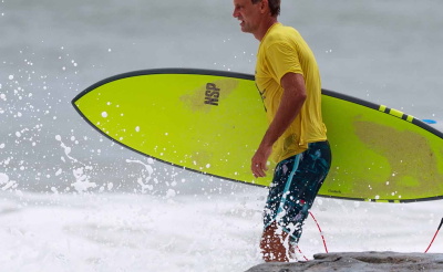 Man rent met een surfboard de zee in